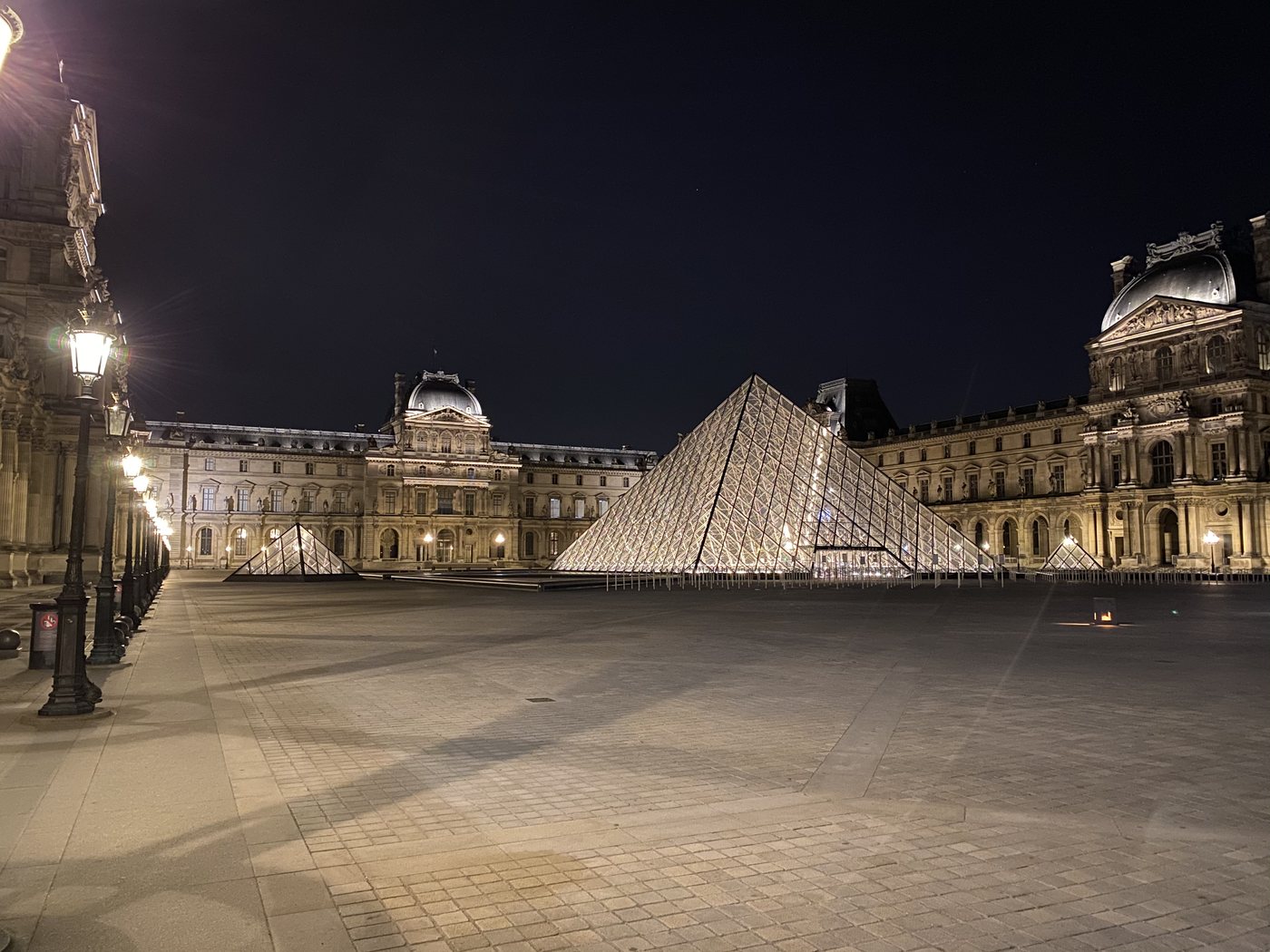 The Louvre pyramid lit up at night in Paris