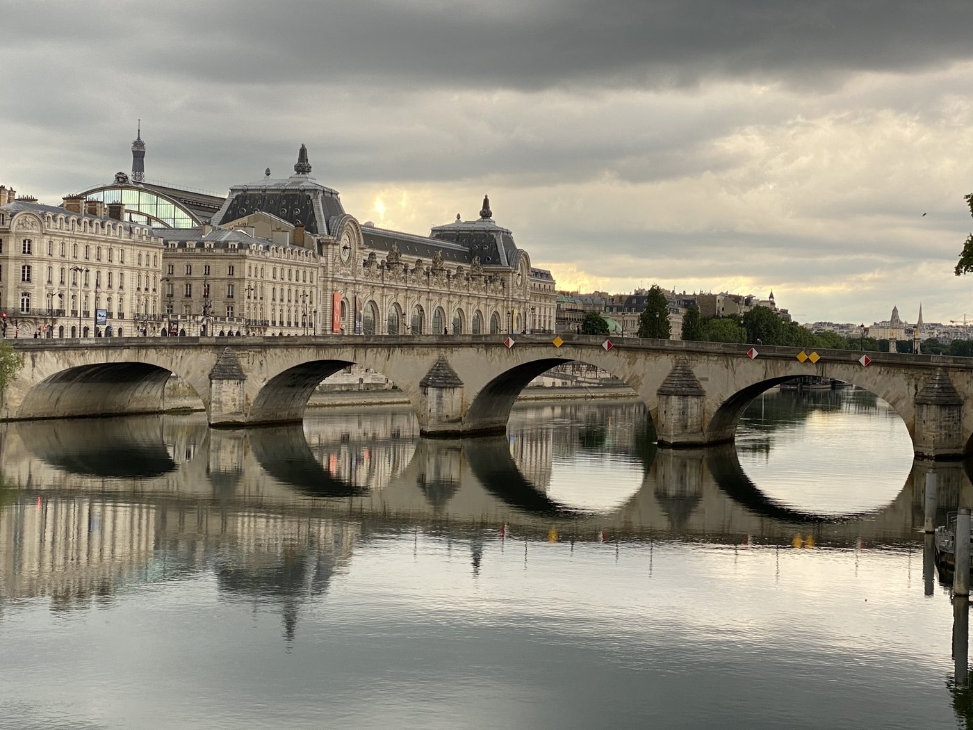 The Pont Royal and the Louvre palace under a dramatic sky in Paris