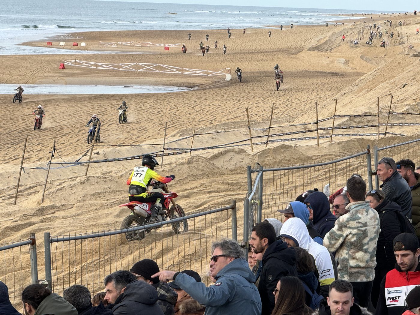 Moto franchissant les dunes devant la foule à la Ronde des Sables d'Hossegor