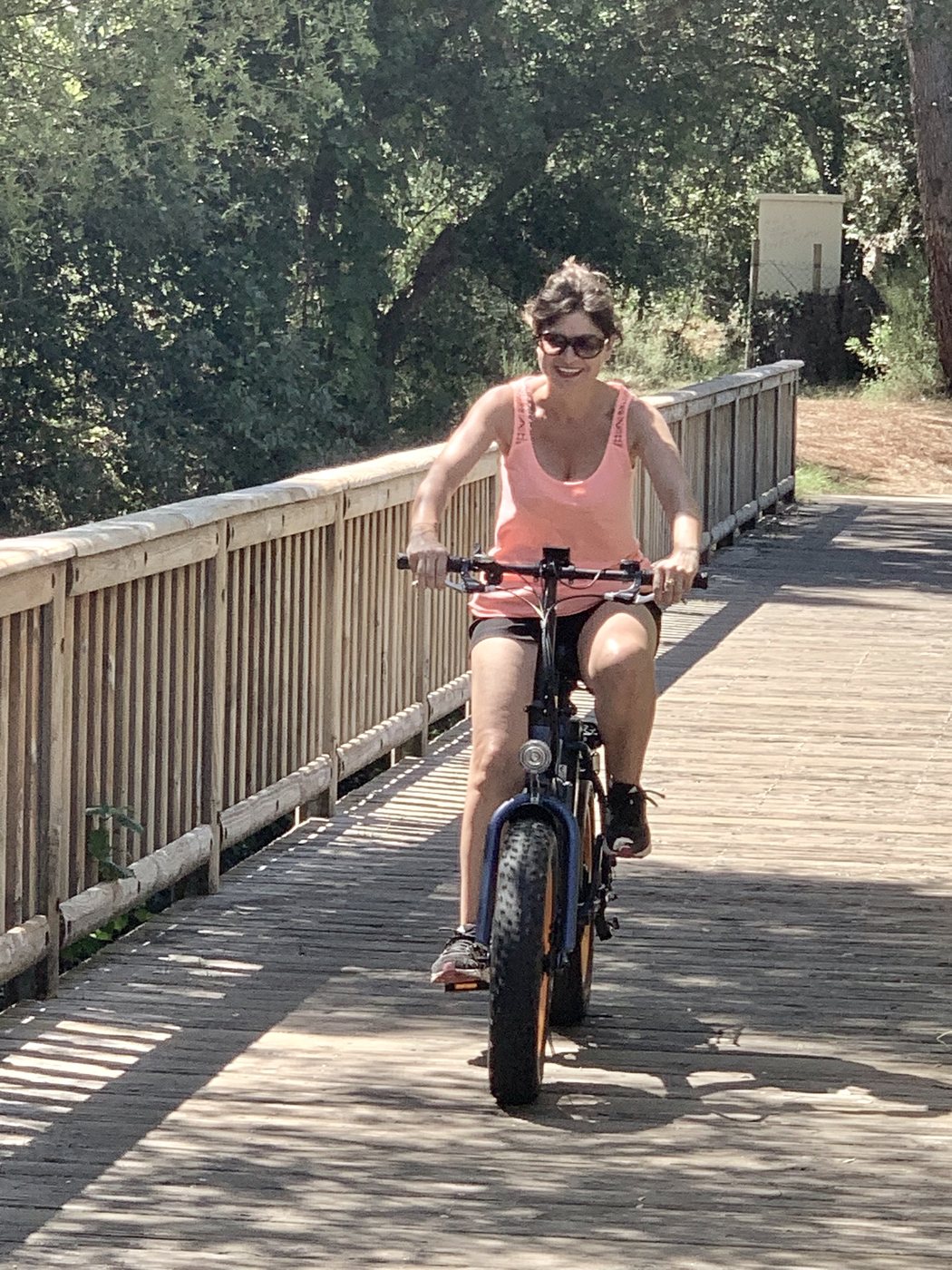 Cycliste sur un ponton en bois à travers la dune boisée à Hossegor